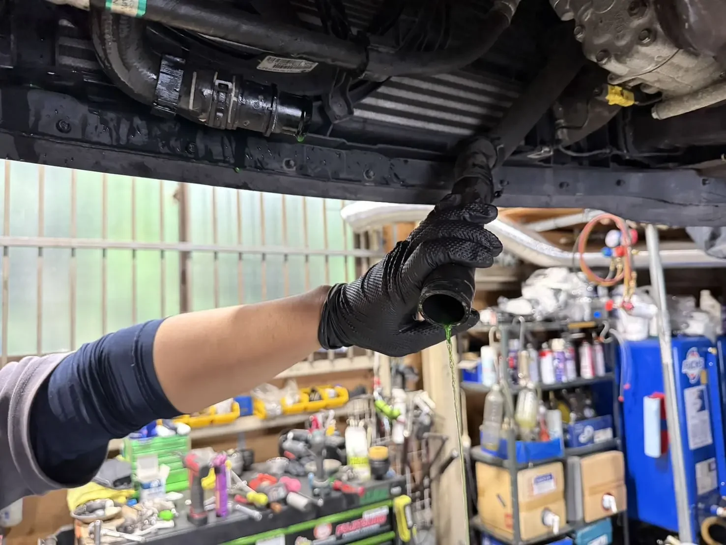 オイルフィルターハウジングのガスケット交換前にクーラントを抜いているところ