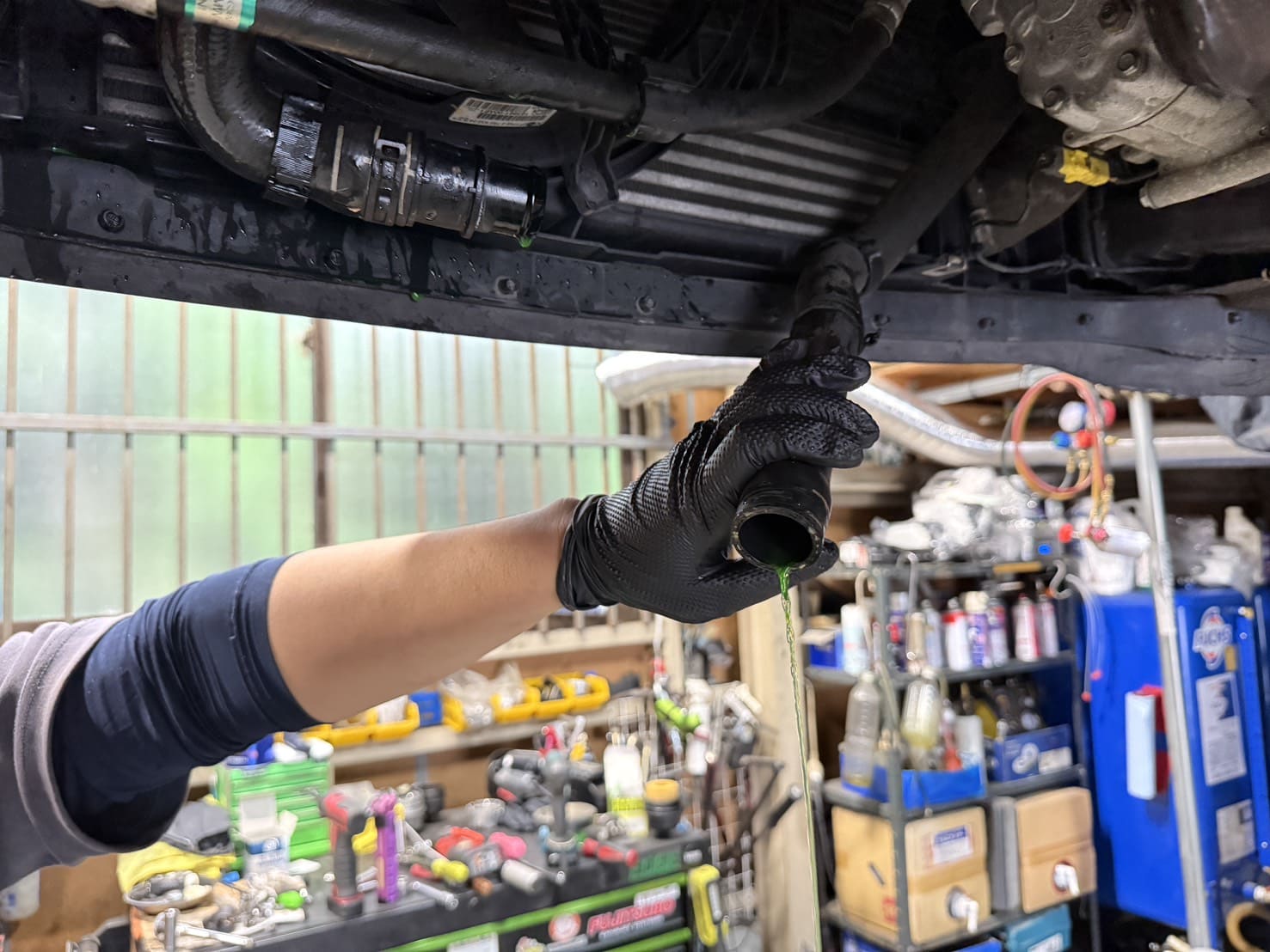 オイルフィルターハウジングのガスケット交換前にクーラントを抜いているところ